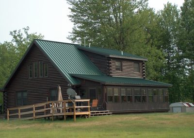 Brown Log Cabin with Forest Green Standing Seam Metal Roof