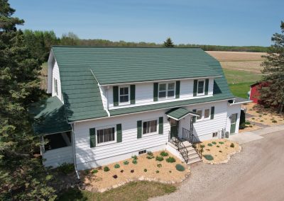Green Oxford Shingle Roof on a White House with Green Shutters