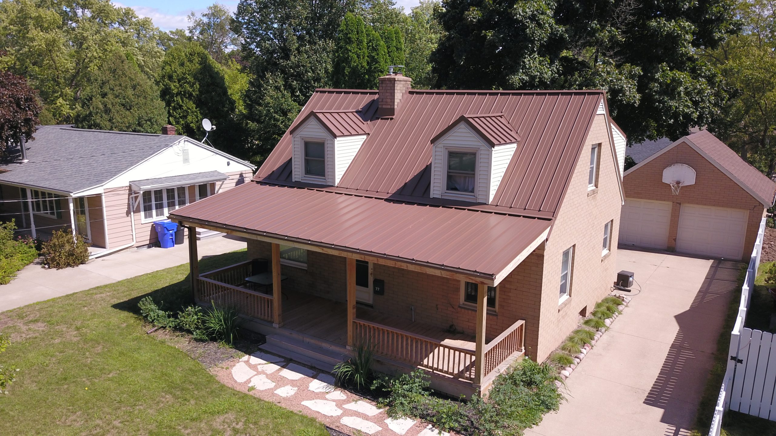 Tan house with Red Standing Seam Metal Roof