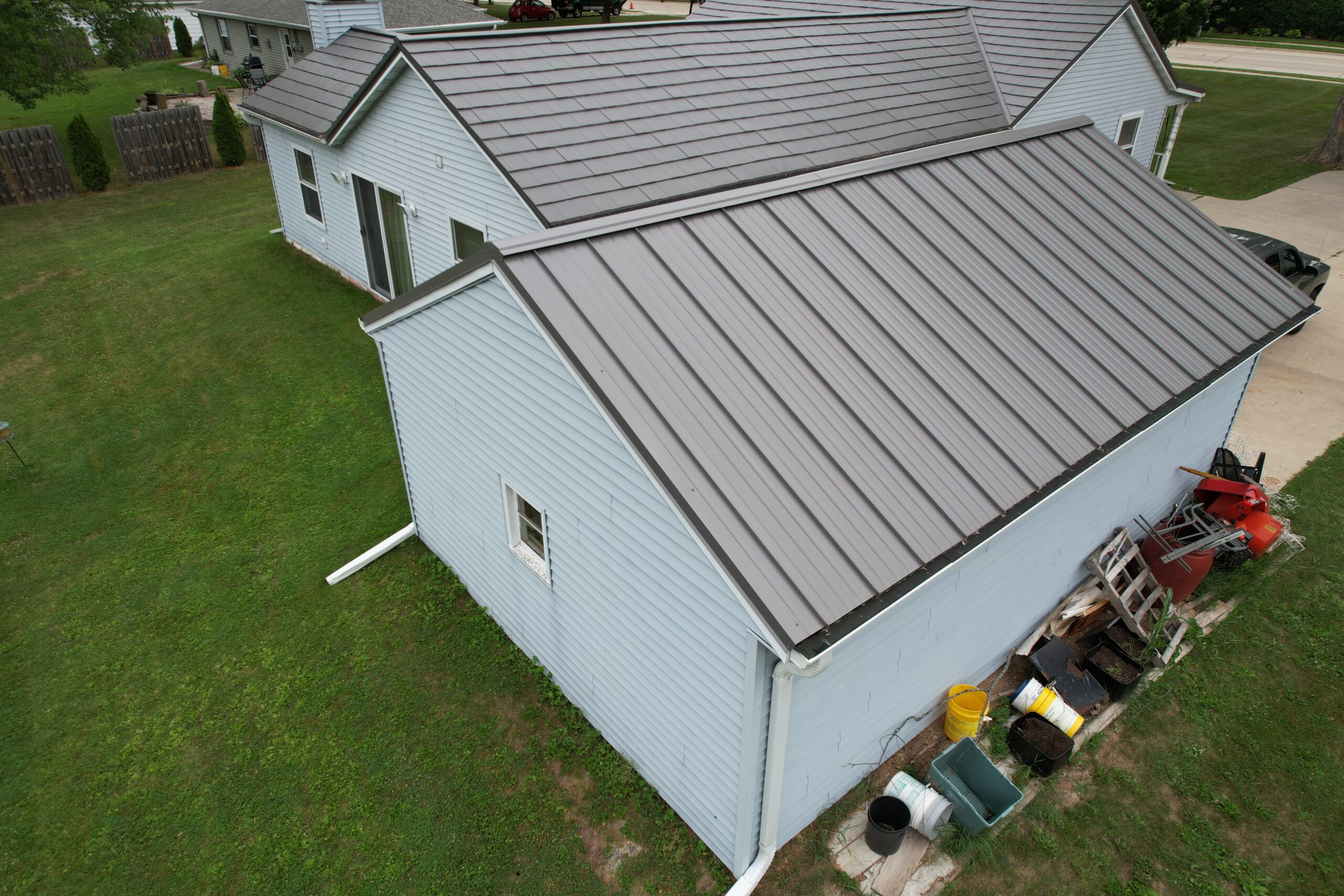 Brown Standing Seam Metal Roof on a White House and Garage