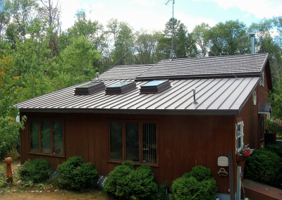 Brown Home with Brown Standing Seam Roof with 3 Skylights