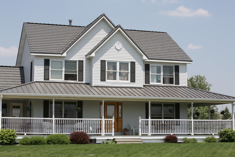 Standing Seam Roof on a white house with black shutters and large porch