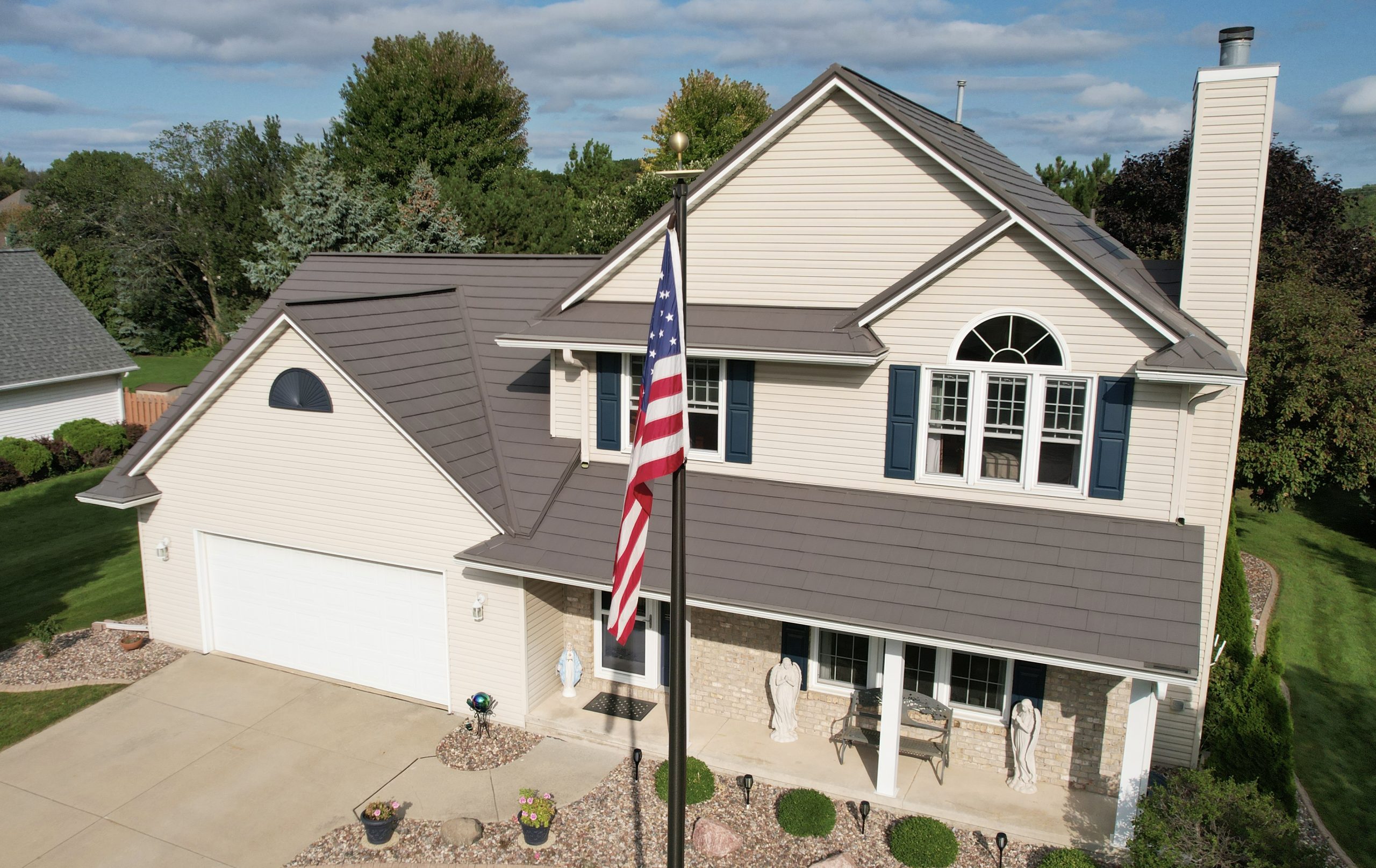 Oxford Metal Roof on a Tan House with an American Flag on a Flag Pole