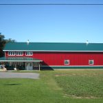 Red commercial barn building with green steel roofing