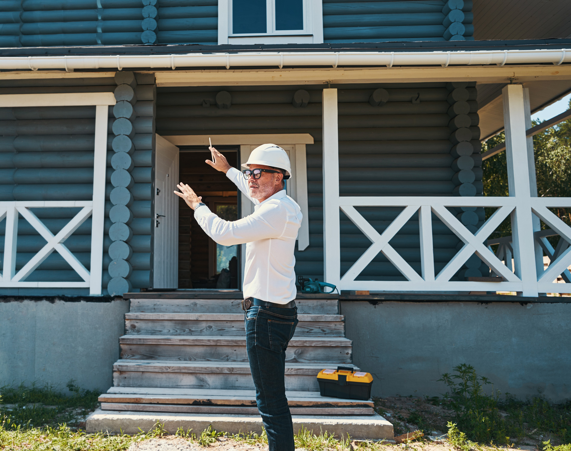 Roofing contractor inspecting roof of a blue log home